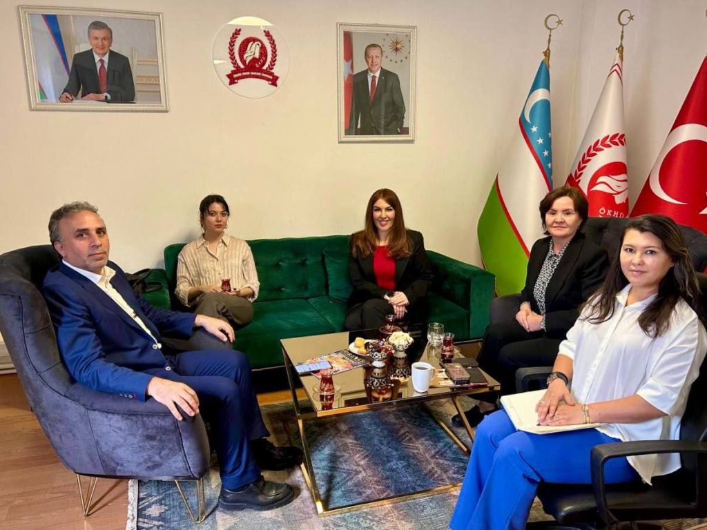 people sitting in a room, flags, pictures of presidents of Turkey and uzbekistan